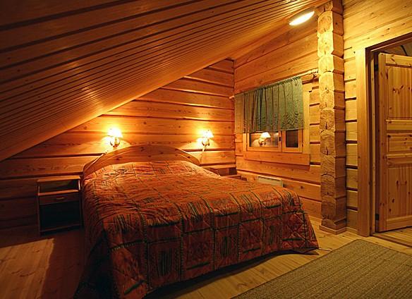 На фото - уютная спальня в мансарде бани