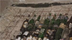 Бутылки закупорены и уложены рядами под сварную сетку